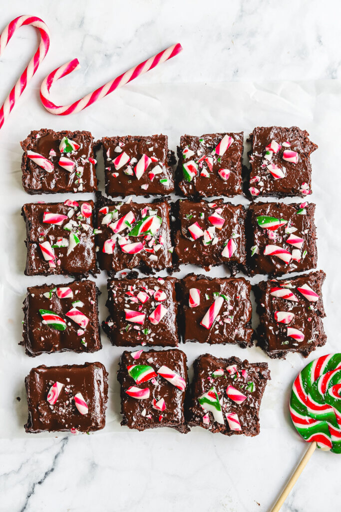 Fudgy Candy Cane Brownies sliced and photographed from the top, showcasing the thick chocolate base, rich ganache layer, and crunchy red, white, and green crushed peppermint candy cane topping. Best Christmas Brownie recipe.