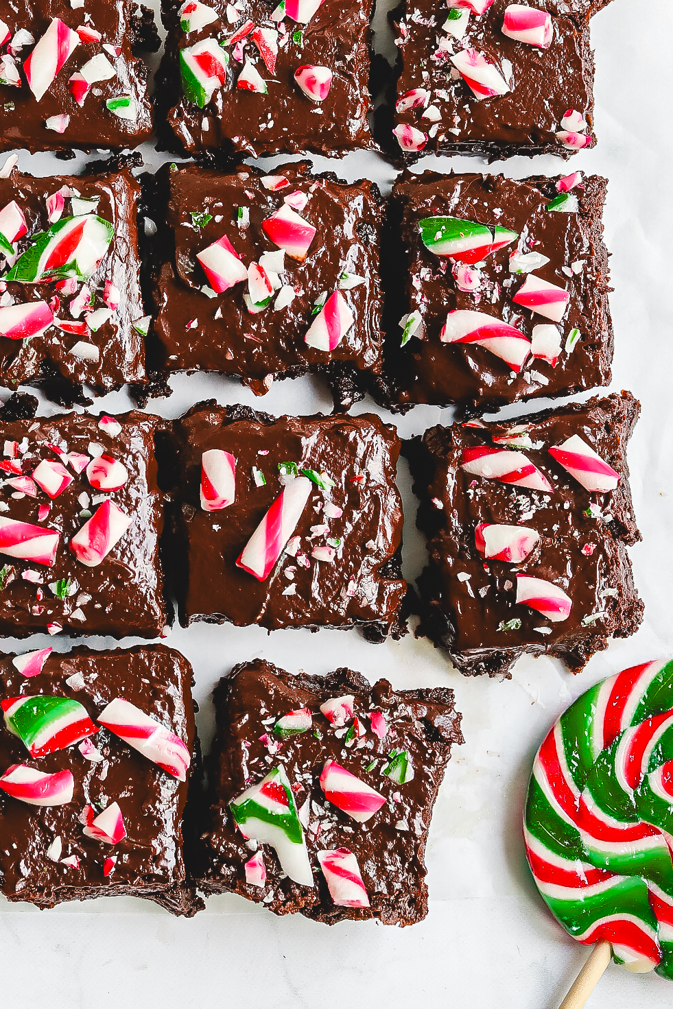 Fudgy Candy Cane Brownies sliced and photographed from the top, showcasing the thick chocolate base, rich ganache layer, and crunchy red, white, and green crushed peppermint candy cane topping. Best Christmas Brownie recipe.