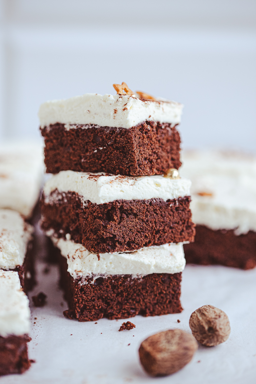 Close-up of a holiday brownie stack, featuring three rich Eggnog Brownie slices with cream cheese frosting, elegantly decorated
