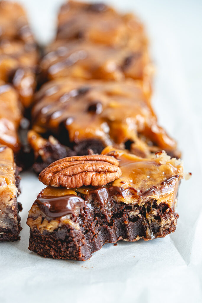 Cross-section of a Turtle Brownie Bar, highlighting the rich fudgy bottom layer and the thick, gooey salted caramel pecan topping.