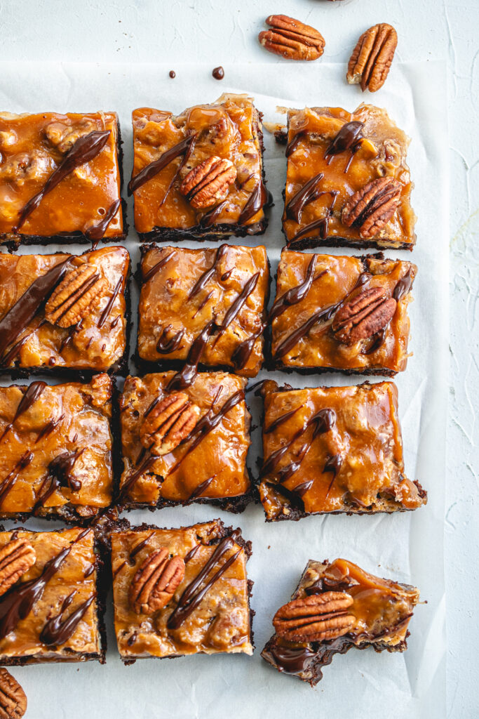 Overhead view of fudgy Salted Caramel Pecan Brownie Bars, generously topped with toasted pecans and flaky sea salt.