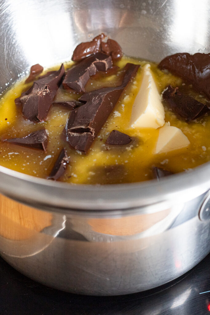 Melted butter and dark chocolate over a double boiler (bain-marie) for fudgy brownie base.