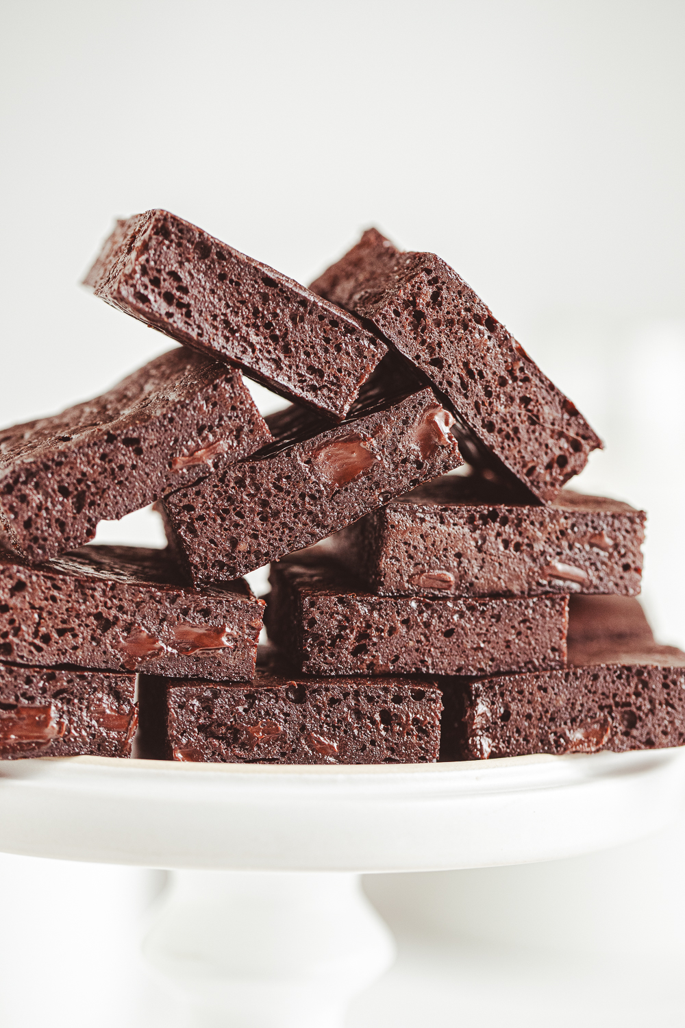 Extreme close-up of fudgy Greek yogurt brownies with visible dark chocolate chunks and a moist, porous texture.